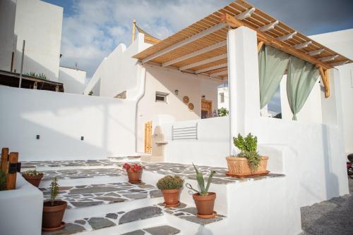 un patio con macetas en un edificio blanco en Mythical Luxury Apartment en Naxos
