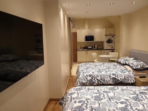 um quarto com 2 camas e uma cozinha com uma mesa em London Luxury Apartments 3 Bedroom Sleeps 8 with 3 Bathrooms 4 mins walk to tube free parking em Ilford