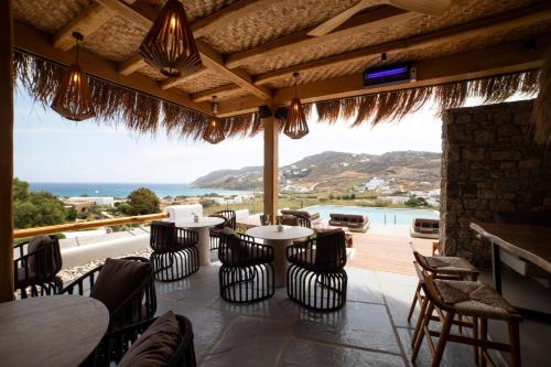 a restaurant with tables and chairs and a view of the ocean at Mileo in Kalo Livadi