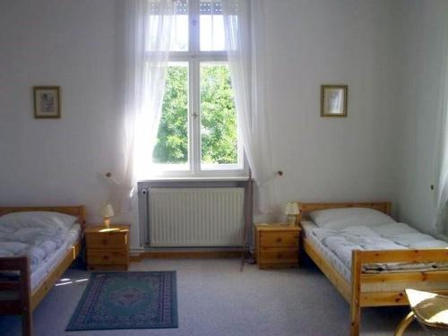 una camera con due letti e una finestra di Ferienwohnungen Heiliger See a Potsdam