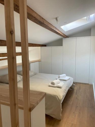 une chambre avec un lit superposé avec des murs blancs et du parquet dans l'établissement L appartement Sète Magnifique duplex climatisé, à Sète