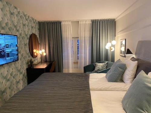 um quarto de hotel com uma cama grande e uma televisão em Hotell Syfabriken em Falköping