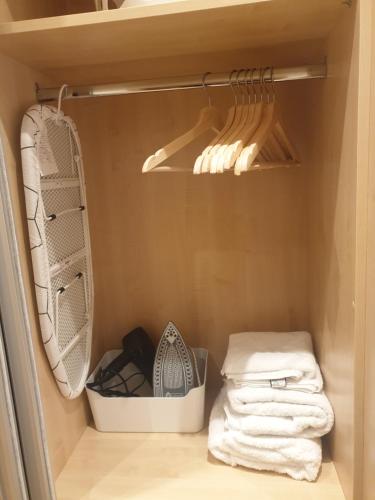 a closet with white towels and a rack with utensils at London Luxury Apartments 3 Bedroom Sleeps 8 with 3 Bathrooms 4 mins walk to tube free parking in Ilford