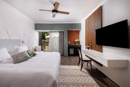 a bedroom with two beds and a flat screen tv at C Hotel Neve Ilan in Neve Ilan