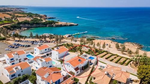 - une vue aérienne sur un complexe et la plage dans l'établissement Beach Front Aqua Marina by Ezoria Villas, à Paralímni