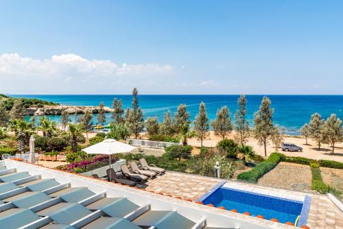 een resort met een zwembad en de oceaan bij Beach Front Aqua Marina by Ezoria Villas in Paralimni