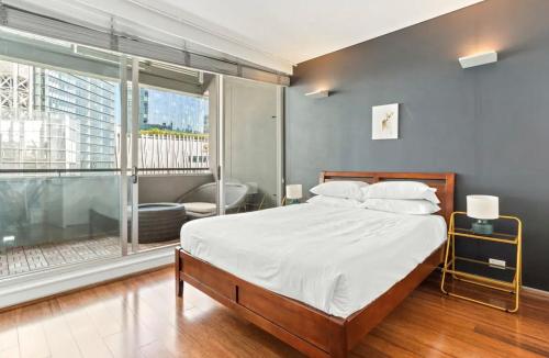 a bedroom with a bed and a large window at Beautiful 2-Bed Apartment with ocean views of Barangaroo in Sydney