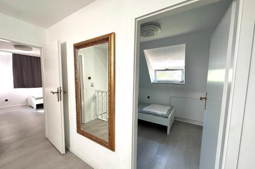 un miroir dans une chambre blanche avec un couloir dans l'établissement Charming House with Garden in Krefeld, à Krefeld
