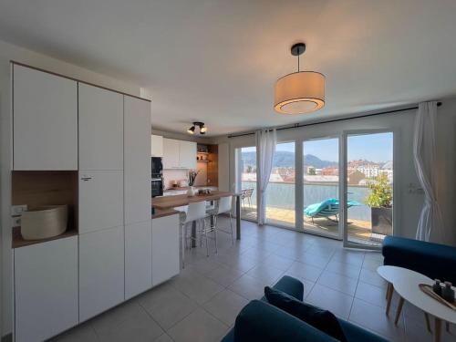 d'une cuisine et d'un salon avec vue sur l'eau. dans l'établissement L'Urban - Parc, centre, parking & balcon avec vue!, à Annecy