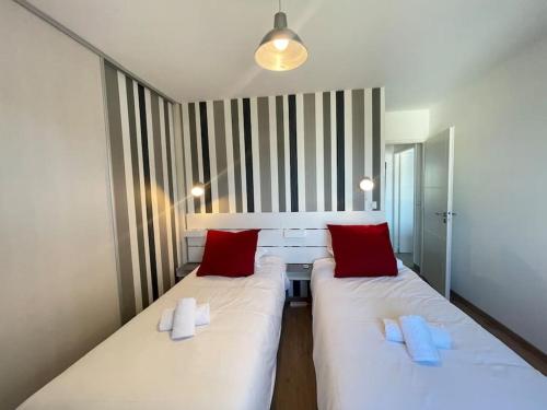 een kamer met 2 witte bedden en rode kussens bij L'Urban - Parc, centre, parking & balcon avec vue! in Annecy