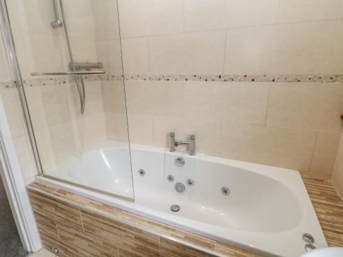 a white bath tub with a glass shower door at Millhouses Hideaway in Sheffield