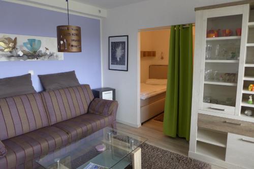 Una sala de estar con un sofá y un dormitorio. en Tief 10 Meerblick mit Internet 304, en Wangerland