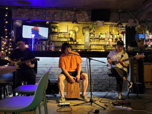 un grupo de personas en un bar tocando instrumentos en INNO Hostel & Pub Lounge Hongdae, en Seúl