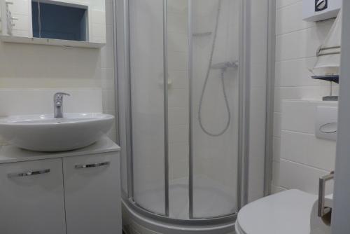 a white bathroom with a shower and a sink at Tief 10 Meeresstern mit Internet504 in Wangerland
