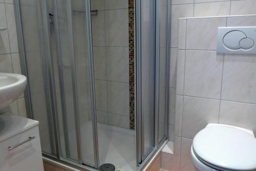 a bathroom with a shower with a toilet and a sink at Tief 12 Hafenkieker mit Internet 53 in Wangerland
