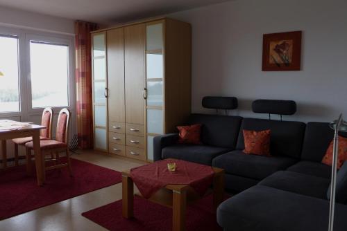 a living room with a blue couch and a table at Tief 12 Hafenkieker mit Internet 53 in Wangerland