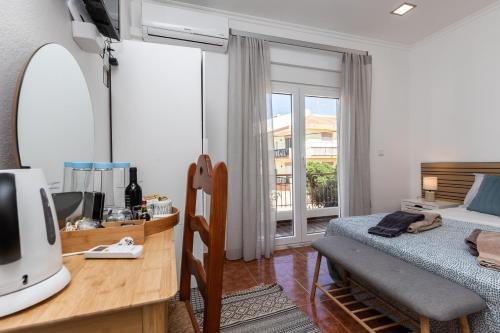 - une chambre avec un lit et un bureau avec un miroir dans l'établissement Porta Nova Guesthouse by R-Tex, à Tavira