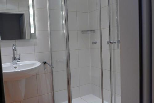 ein Bad mit einer Dusche und einem Waschbecken in der Unterkunft Tief 12 Strandkieker mit Internet und Strandkorb 54 in Wangerland