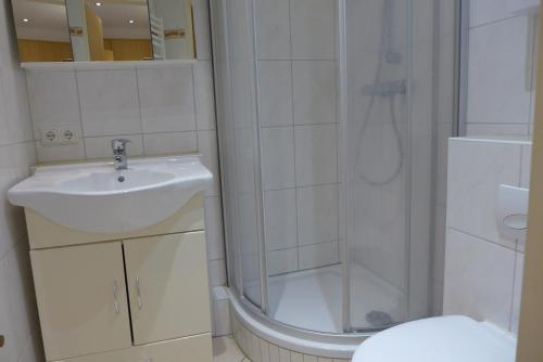 a bathroom with a sink and a shower and a toilet at Tief 10 Steuerbord 502 in Wangerland