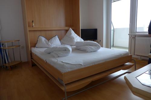 a bedroom with a bed with pillows on it at Tief 10 Austernfischer 708 in Wangerland