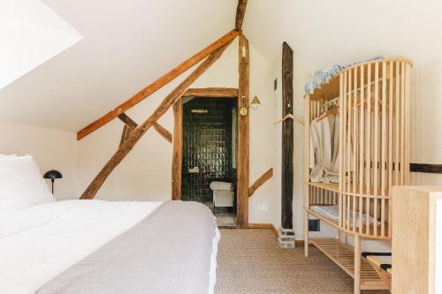 Les Callots - Maison d'hôtes في Champignelles: غرفة نوم بسرير ابيض وسرير اطفال