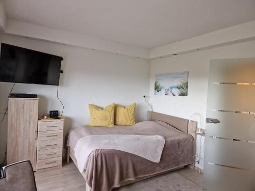 um quarto com uma cama e uma televisão de ecrã plano em Tief 10 7 em Wangerland