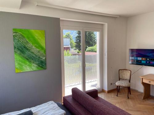 een woonkamer met een bank en een raam bij my Relaxs little Villa in Bludenz