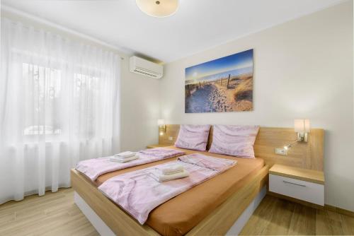 een slaapkamer met een groot bed met roze lakens bij Apartment Stanko in Poreč