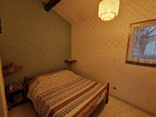 um quarto com uma cama e uma janela em MAS DE LA PLAGE em Portiragnes