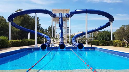 a swimming pool with a blue water slide at Casa Familiar Tarragona playa in Tarragona