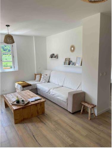 a living room with a white couch and a coffee table at Le gîte de château vieux in Guillaumes