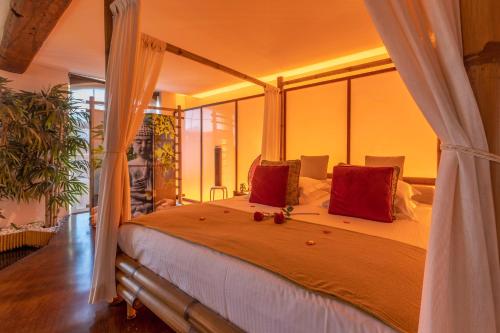 ein Schlafzimmer mit einem großen Bett mit roten Kissen in der Unterkunft Le Baiser de Shogun in Ensival