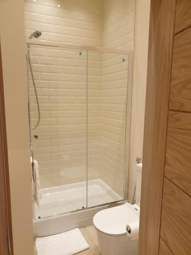 a bathroom with a toilet and a glass shower at London Luxury Apartments 3 Bedroom Sleeps 8 with 3 Bathrooms 5 mins Walk to tube station free parking in Ilford