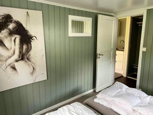 - une chambre avec des murs verts, un lit et une photo dans l'établissement Dalsøren Camping og hytter, à Luster