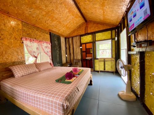 Un dormitorio con una cama con una bandeja de flores. en Numpu Baandin, en Sam Roi Yot
