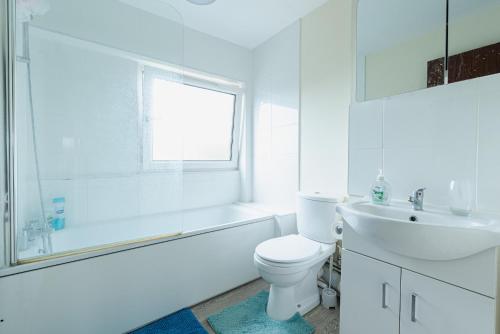 a white bathroom with a toilet and a sink at Professional House in Kent