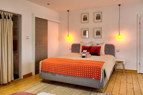 um quarto com uma cama grande e um cobertor laranja em La Maison Forestière em Niederbronn-les-Bains