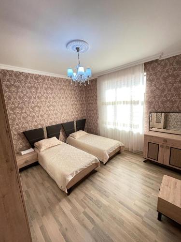 a bedroom with two beds and a chandelier at Villa in Gabala in Gabala