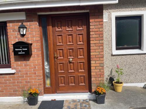 a wooden door on the side of a brick building at Harmony House enclosed property near beach and lake in Tramore