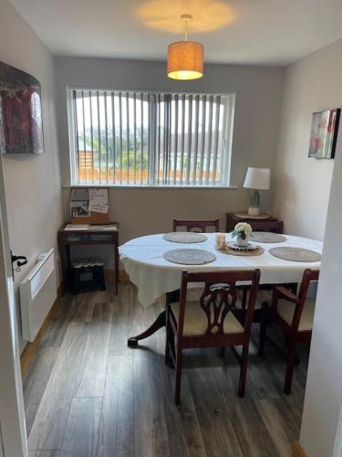 a dining room with a table and chairs and a room with a table at Harmony House enclosed property near beach and lake in Tramore