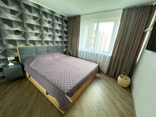 - une chambre avec un lit et une grande fenêtre dans l'établissement Apartment in Birstonas, à Birštonas