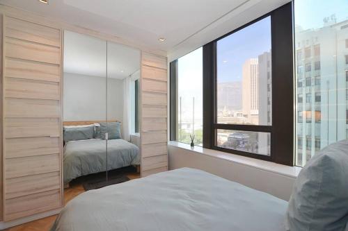 1 Schlafzimmer mit 2 Betten und einem großen Fenster in der Unterkunft Foreshore Place Suites in Kapstadt