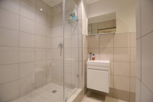 ein Bad mit einer Dusche und einer Glastür in der Unterkunft Foreshore Place Suites in Kapstadt
