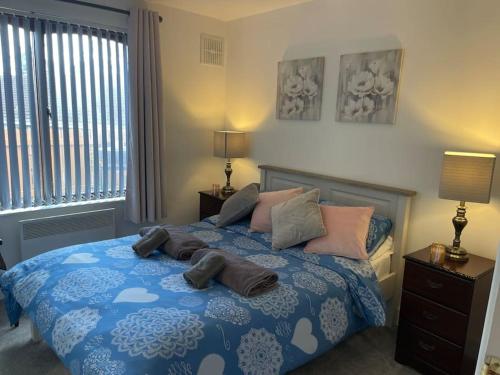 a bedroom with a blue bed with pillows on it at Harmony House enclosed property near beach and lake in Tramore