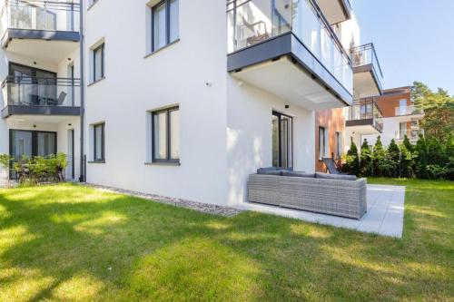 a large white building with a lawn in front of it at Double Rest in Jastrzębia Góra