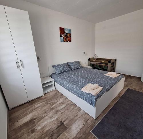 a bedroom with a bed with a blue comforter at Apartmani KOKI Kladovo in Kladovo