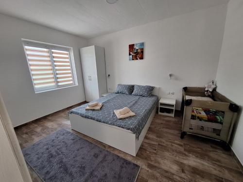 1 dormitorio con 1 cama con 2 toallas en Apartmani KOKI Kladovo, en Kladovo