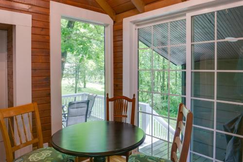 a porch with a table and chairs and a window at Cozy Tennessee Cabin with Deck, Grill and Fire Pit! in Tullahoma