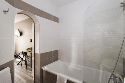 a bathroom with a tub and a table at Hôtel Suzane in Angers