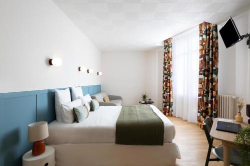 um quarto com uma grande cama branca e uma secretária em Hôtel Suzane em Angers